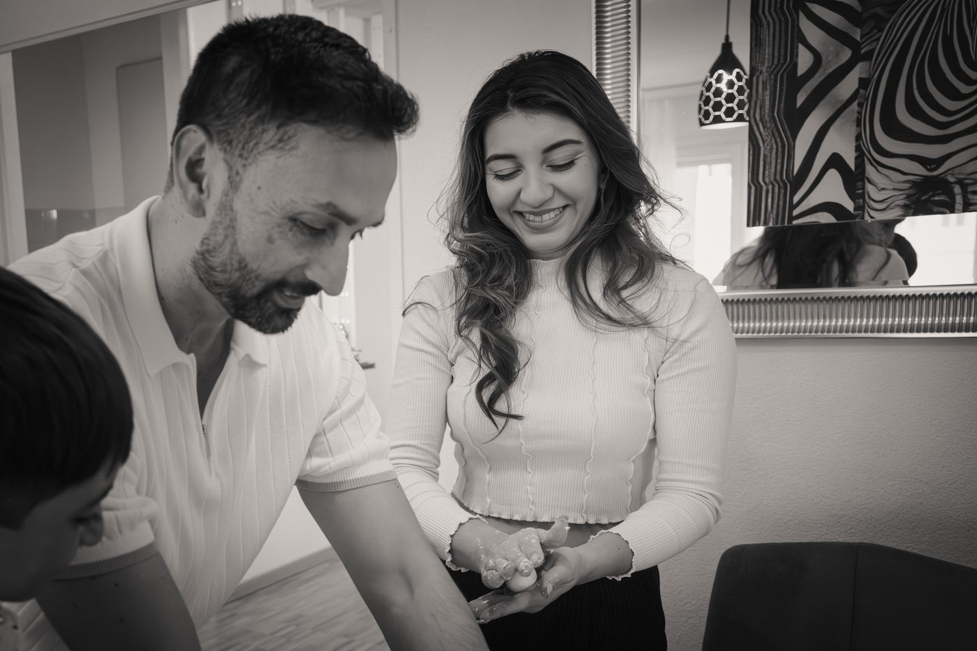 Une famille prépare un repas ensemble dans la cuisine, photo en noir et blanc