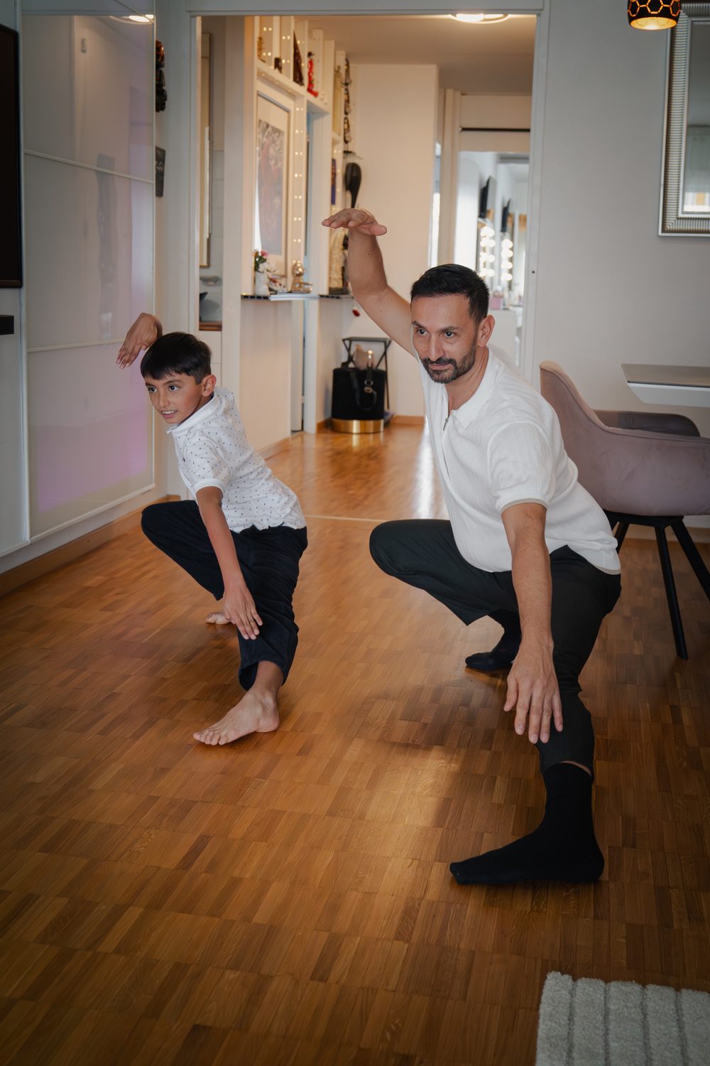 Un père et son fils dansent dans le salon